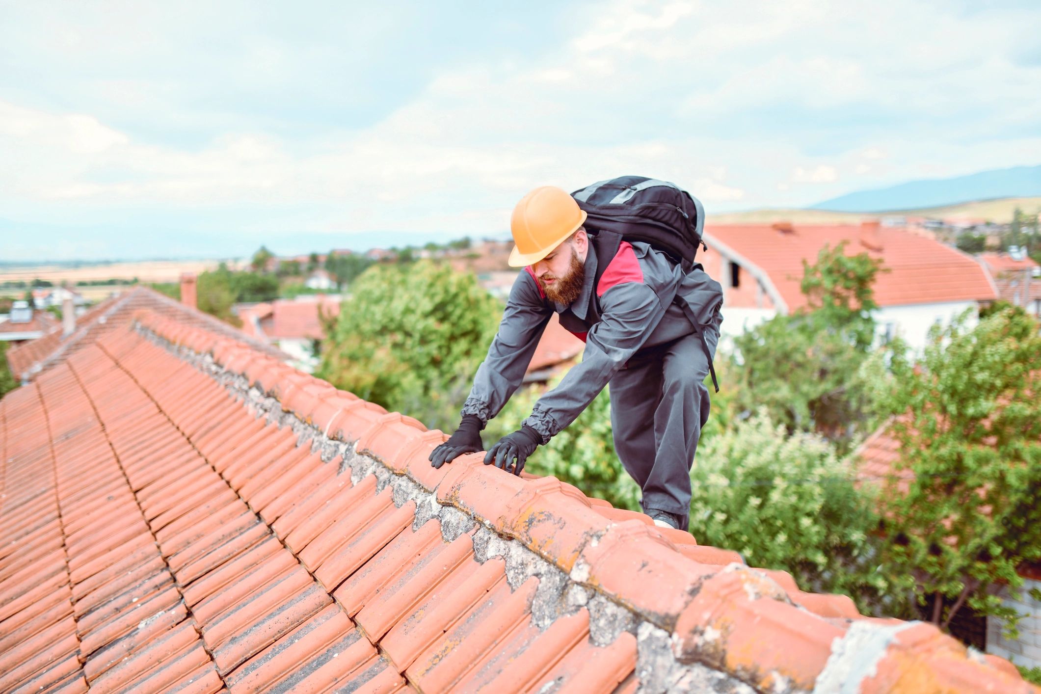 Roofing professional climbing onto a roof for inspection